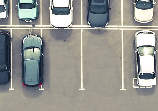 Full parking lot with 2 empty spaces