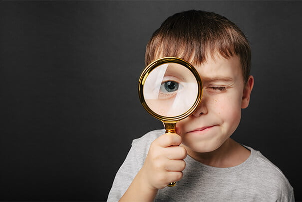 Young boy looking through magnifying glass