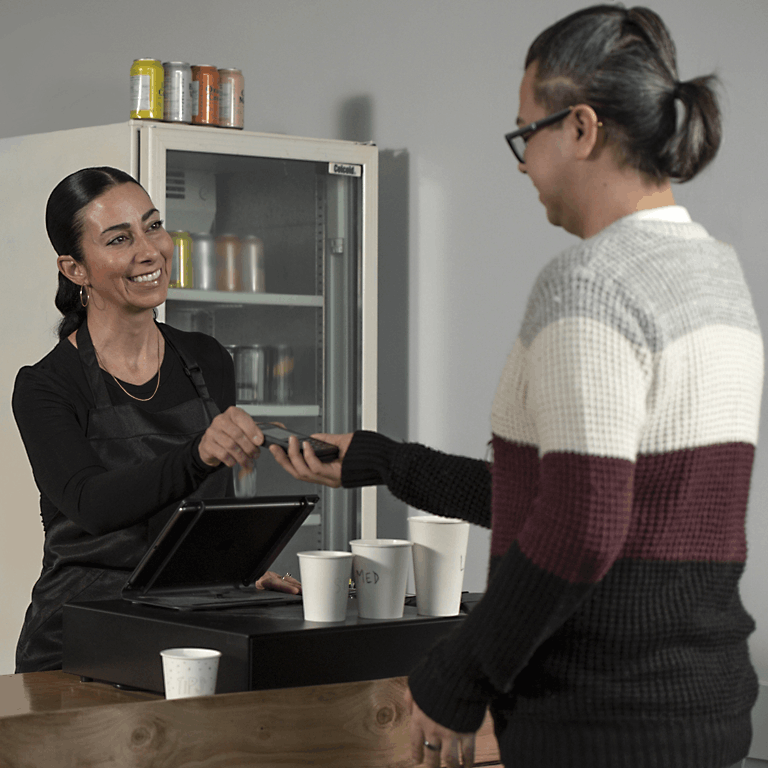 female business owner working cash register at coffee shop