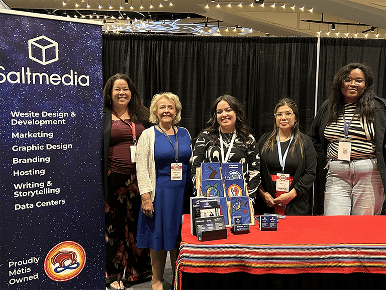 Angie, Brandi, Ellie, and Natalya standing in Saltmedia Booth at Trailblazers Booth